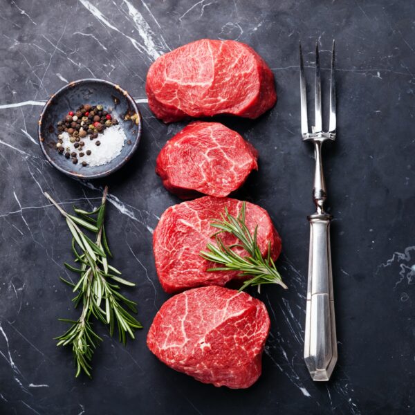 raw-fresh-marbled-meat-steak-seasonings-and-meat-fork-on-dark-marble-background.jpg